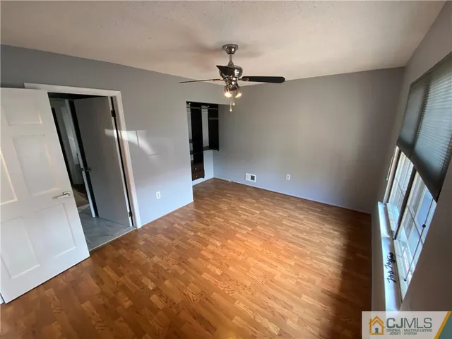 an empty room with a window and a fan