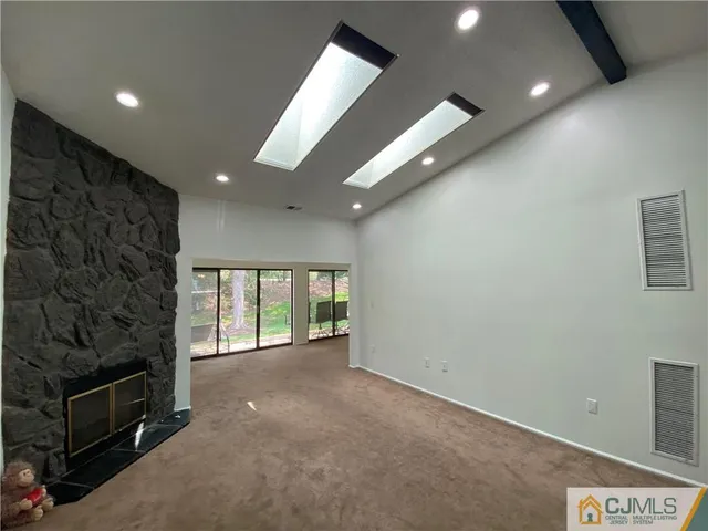 a view of an empty room with a fireplace and a window