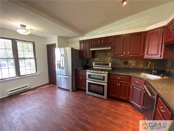 a kitchen with stainless steel appliances granite countertop a refrigerator and a stove top oven