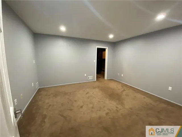 an empty room with closet and windows