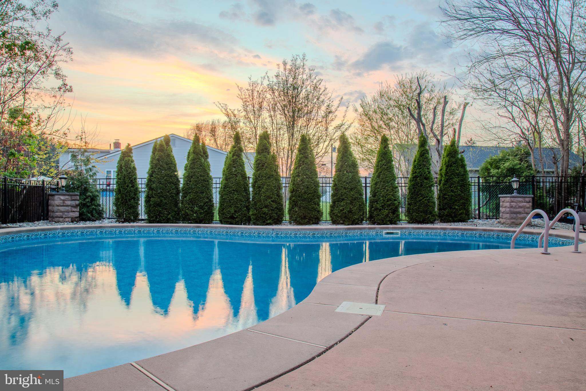 33 Evesham Avenue Marlton, NJ 08053 - Photo 8 of 45 a view of a swimming pool with a bench and trees in the background