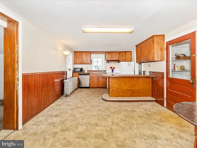 a kitchen with white cabinets and white appliances