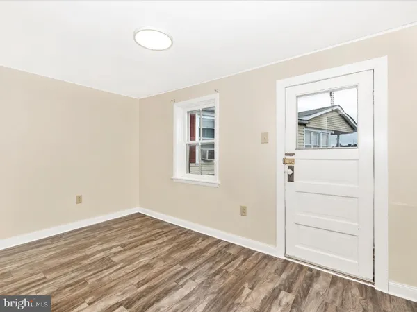 a view of an empty room with window and closet