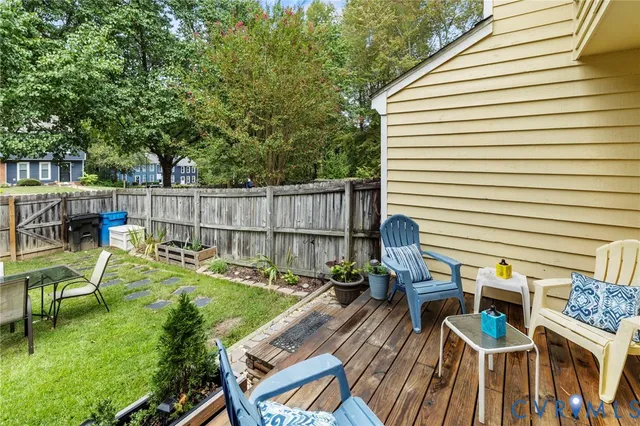 a view of a patio with table and chairs with wooden floor and fence