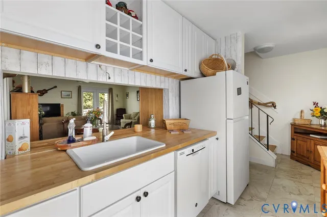 a kitchen with stainless steel appliances granite countertop a sink and white cabinets