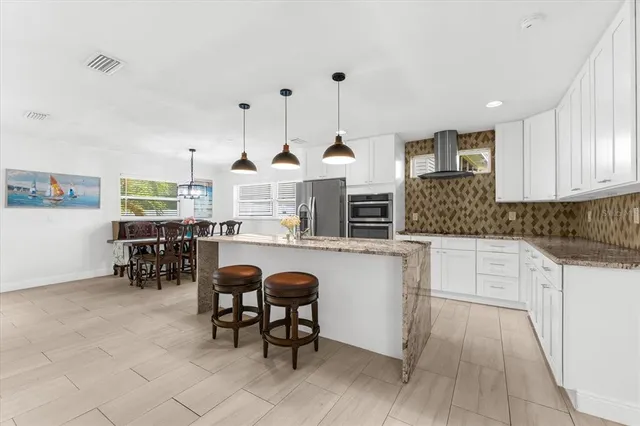 a kitchen with stainless steel appliances granite countertop a sink and a wooden floors