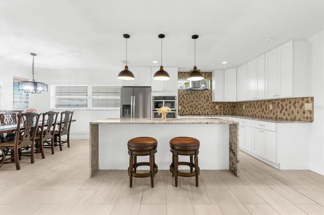 a kitchen with granite countertop a table and chairs in it