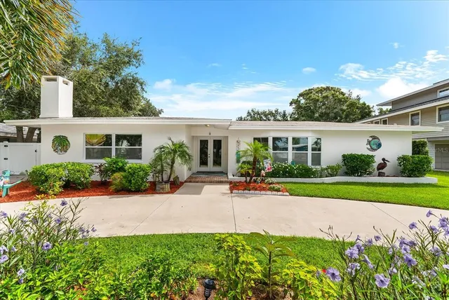 front view of house with a yard and potted plants