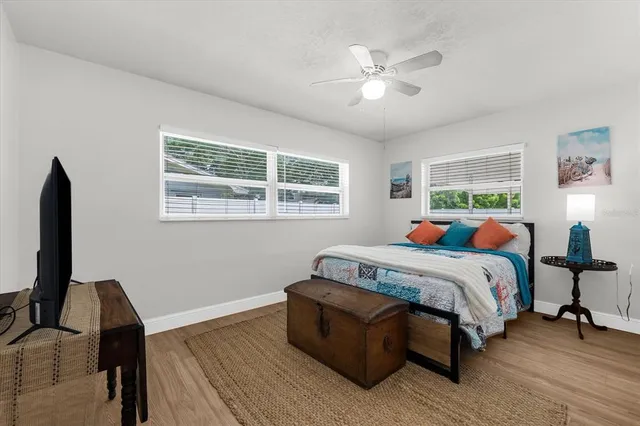 a bedroom with a bed wooden floor and a window