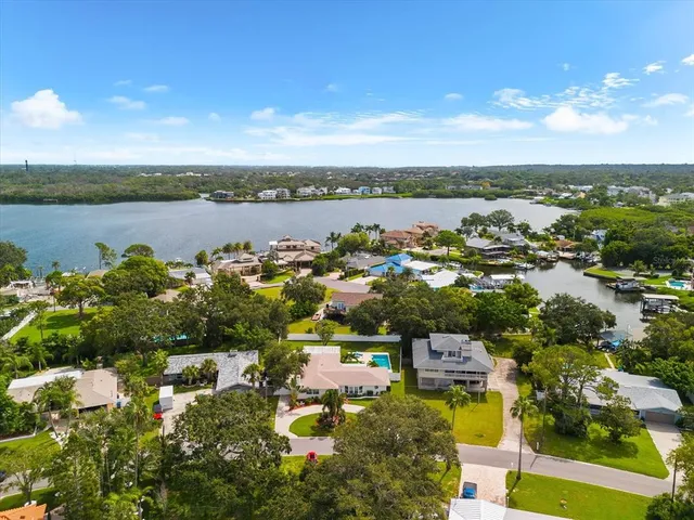 an aerial view of a city with lots of residential buildings ocean and mountain view in back