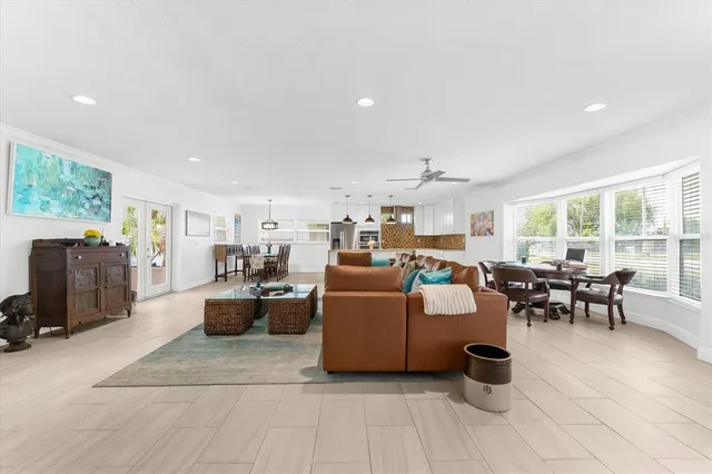 a living room with furniture and a dining table with kitchen view