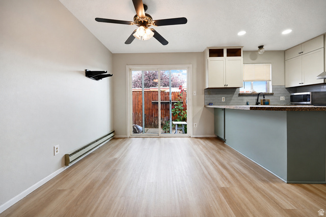285 West 600 North, Unit 2 Logan, UT 84321 - Photo 7 of 21 Open-concept living space with wood-finish flooring, a contemporary ceiling fan, and a sliding glass door providing direct access to the outdoor area