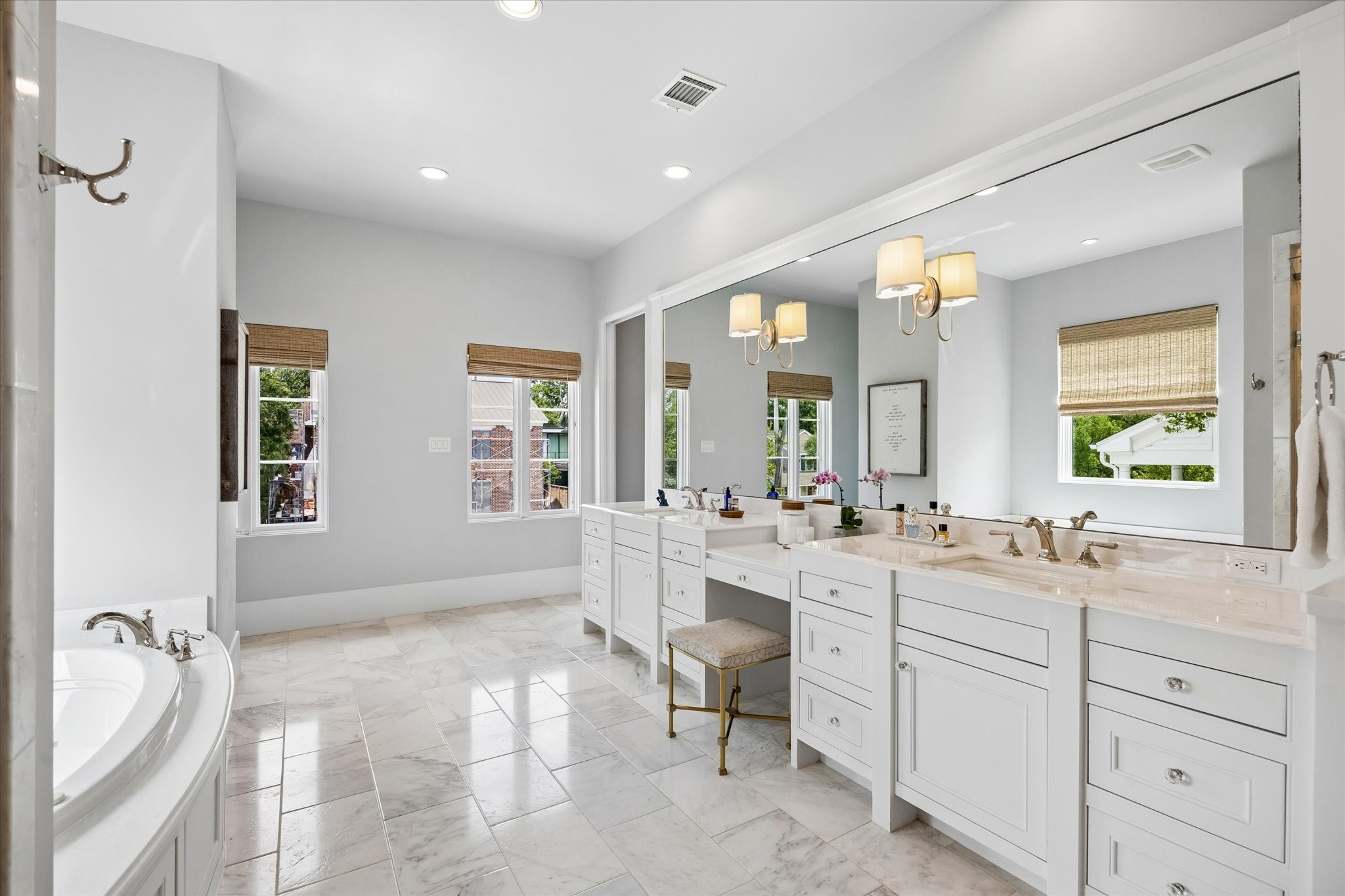 3615 Overbrook Lane Houston, TX 77027 - Photo 23 of 34 a spacious bathroom with a double vanity sink a mirror a bathtub and next to a window