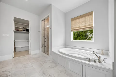 a bathroom with a granite countertop sink and a bathtub