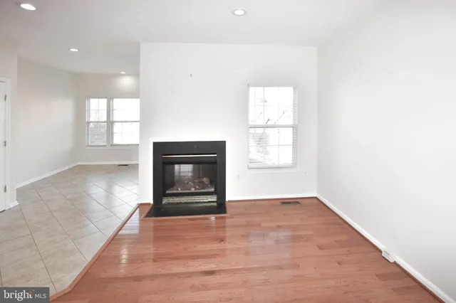 an empty room with windows and fireplace