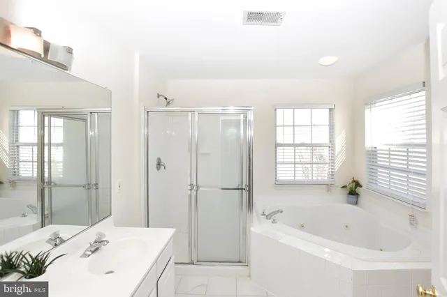 a bathroom with a bathtub shower and a sink