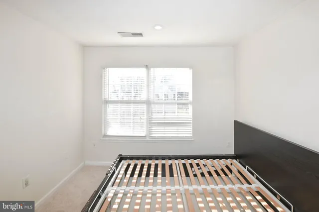 a view of a bedroom with a bed and a table