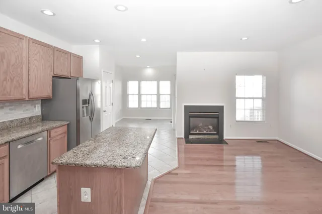 a kitchen with granite countertop a refrigerator and a stove top oven