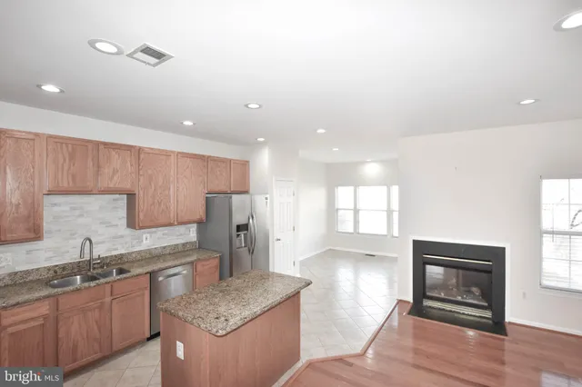 a kitchen with granite countertop cabinets stainless steel appliances a sink and a window