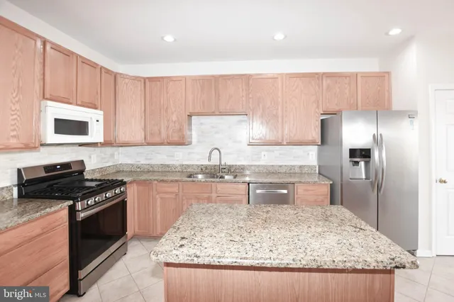 a kitchen with a sink stove top oven and refrigerator