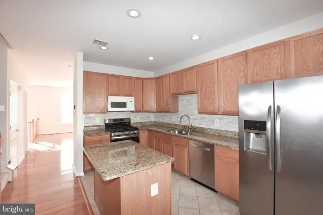 a kitchen with stainless steel appliances granite countertop a stove top oven a sink and dishwasher