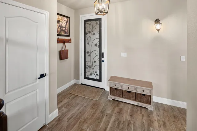 a view of a hallway with wooden floor and staircase