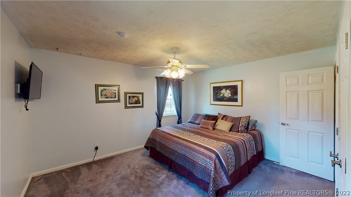 2678 County Line Road St. Pauls, NC 28384 - Photo 21 of 36 a bedroom with a bed and a chandelier