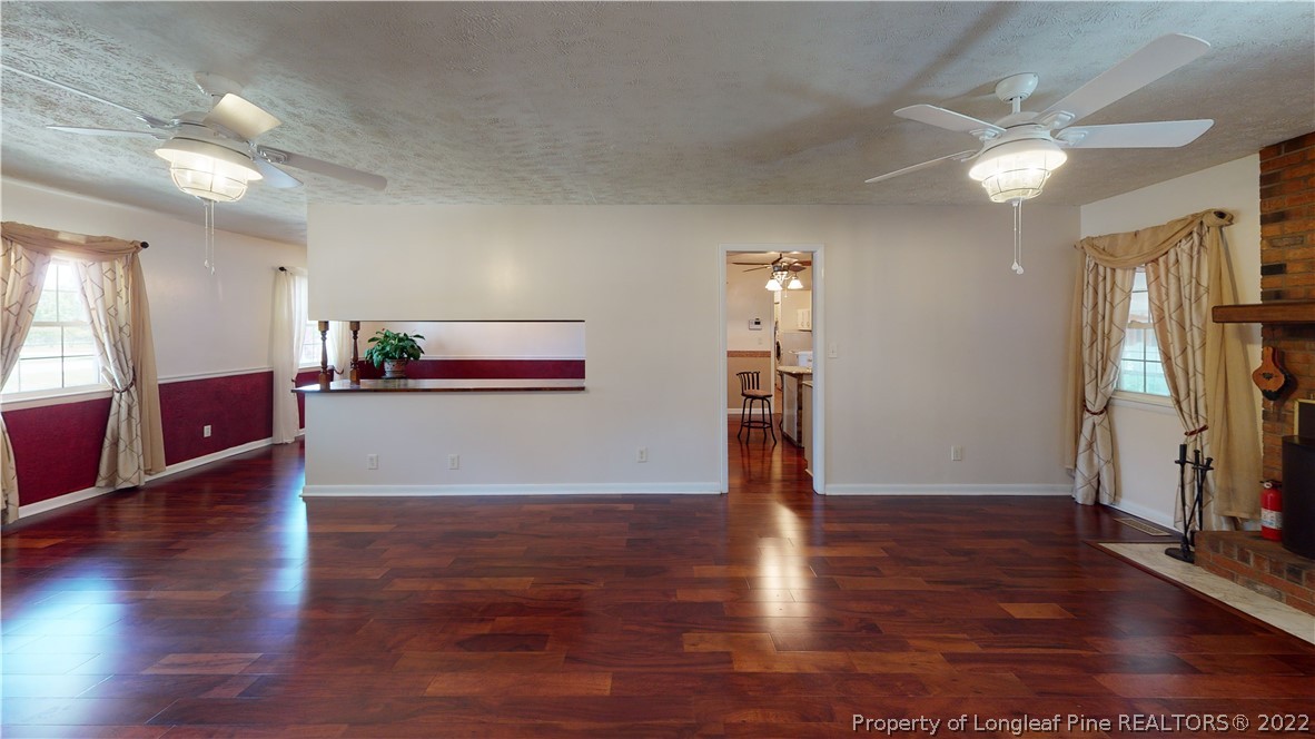 2678 County Line Road St. Pauls, NC 28384 - Photo 7 of 36 a view of a kitchen with wooden floor and a ceiling fan