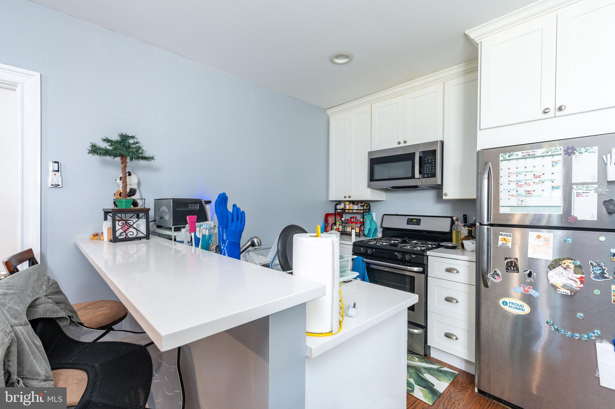 109-15 Carpenter Lane Philadelphia, PA 19119 - Photo 41 of 47 a kitchen with stainless steel appliances a stove a sink a microwave a refrigerator and white cabinets