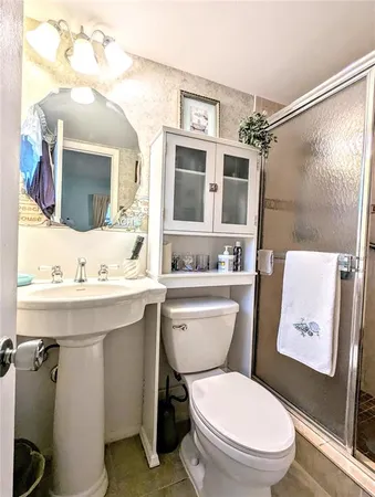 a bathroom with a granite countertop toilet sink and mirror