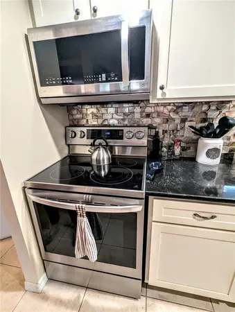 a kitchen with stove top oven and cabinets
