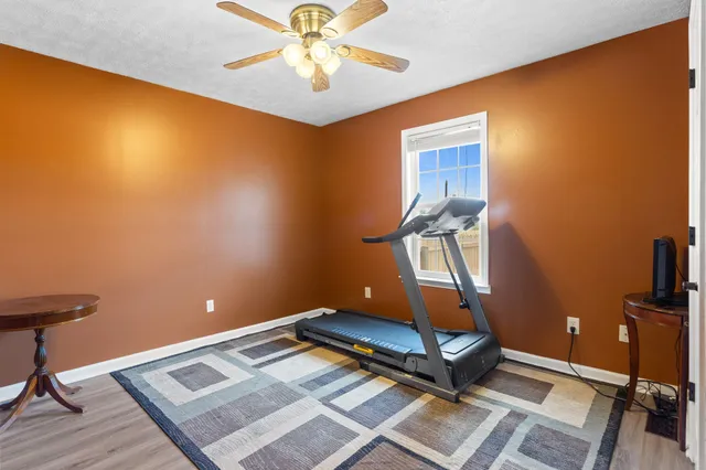 a room with gym equipment and wooden floor
