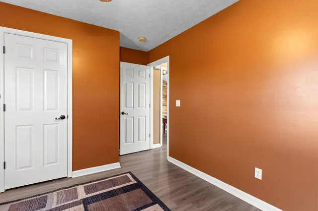 an empty room with wooden floor and closet