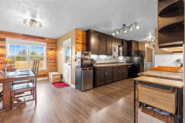 a kitchen with a stove a refrigerator and wooden floor