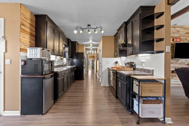 a kitchen with stainless steel appliances granite countertop a refrigerator stove top oven and sink