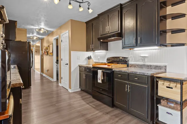 a kitchen with stainless steel appliances granite countertop a refrigerator a stove and a sink