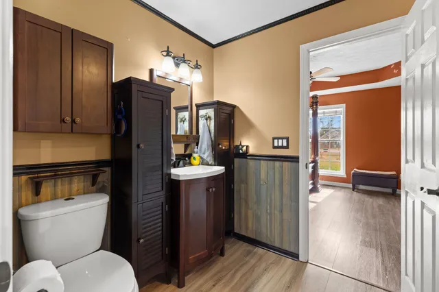 a bathroom with a toilet a sink and mirror