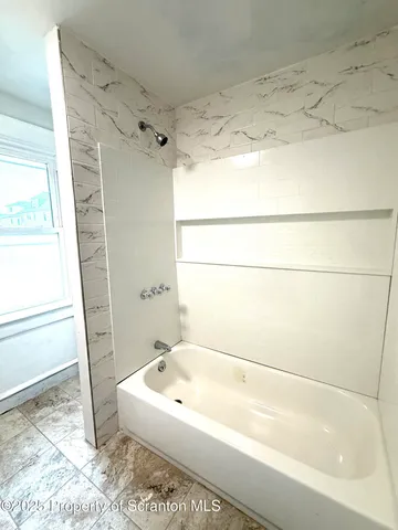 a bathroom with a bathtub and a shower