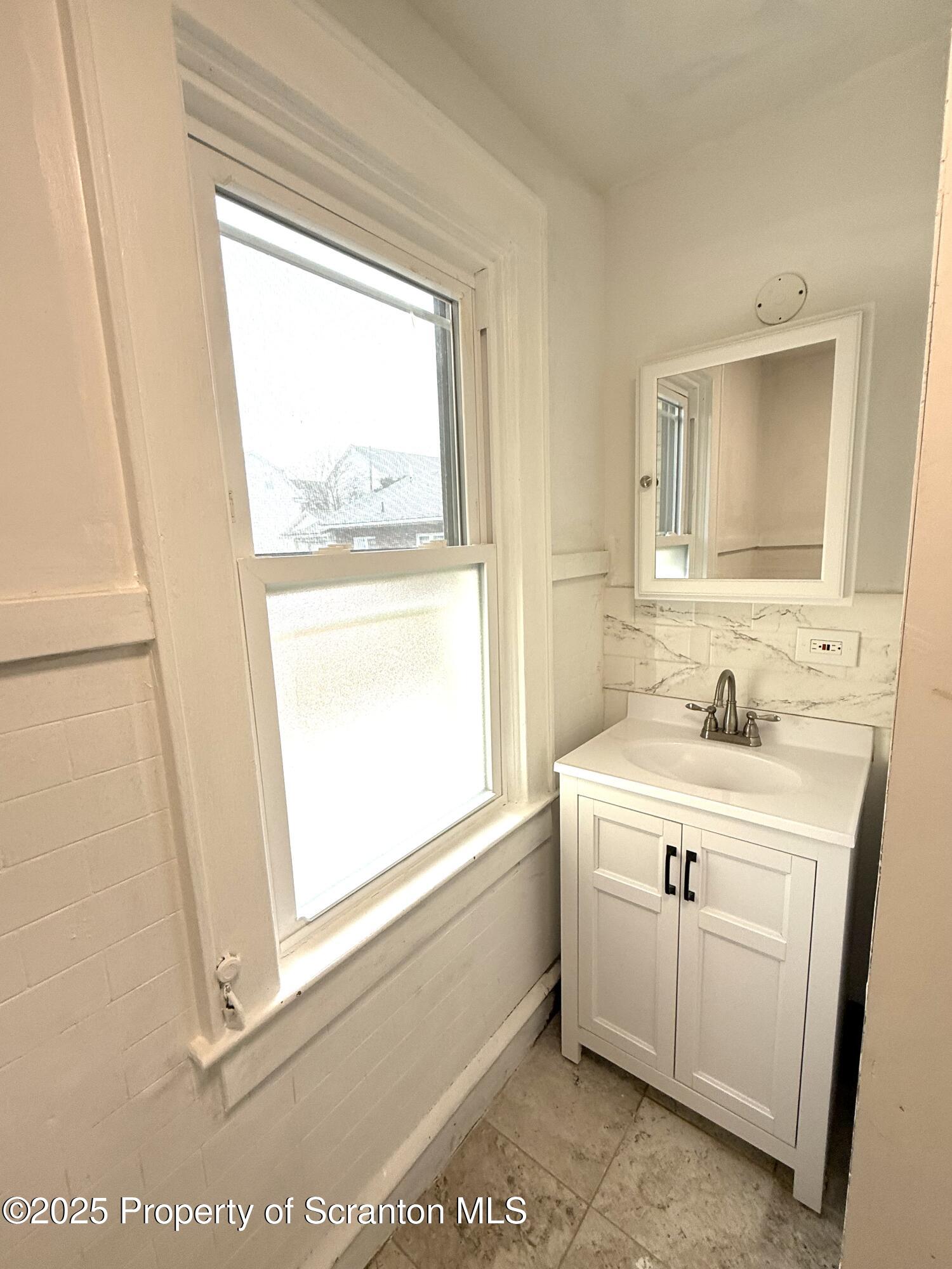 37 Shea Street, Unit 2 Nanticoke, PA 18634 - Photo 13 of 24 a bathroom with a sink a mirror and a window