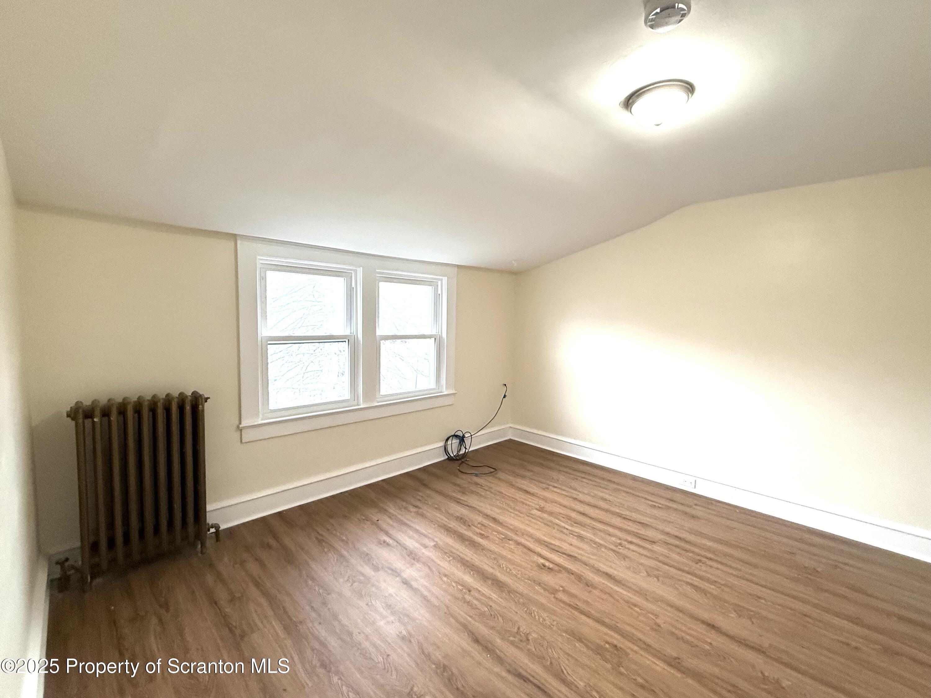37 Shea Street, Unit 2 Nanticoke, PA 18634 - Photo 16 of 24 an empty room with wooden floor and windows