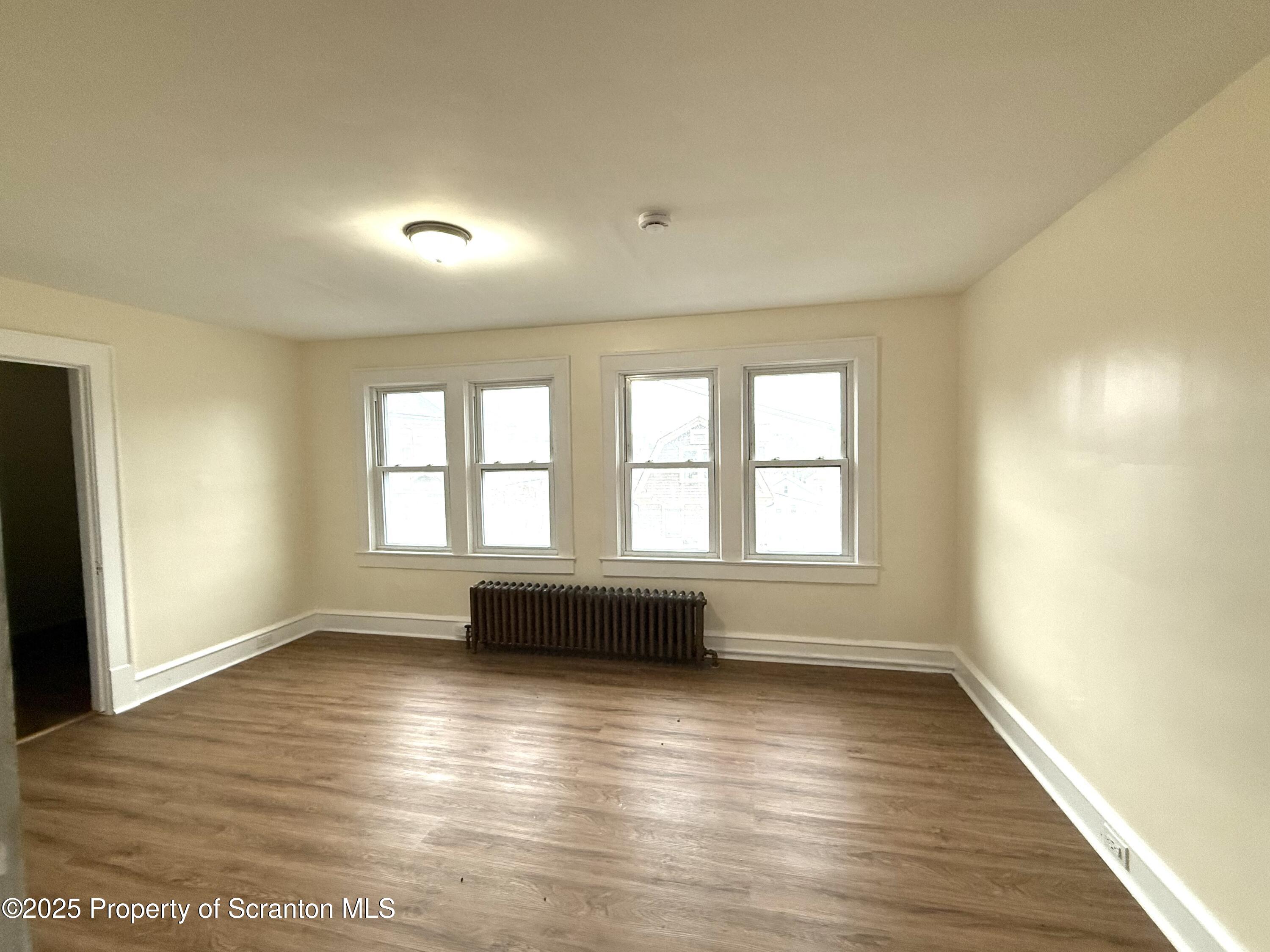 37 Shea Street, Unit 2 Nanticoke, PA 18634 - Photo 21 of 24 an empty room with wooden floor and windows