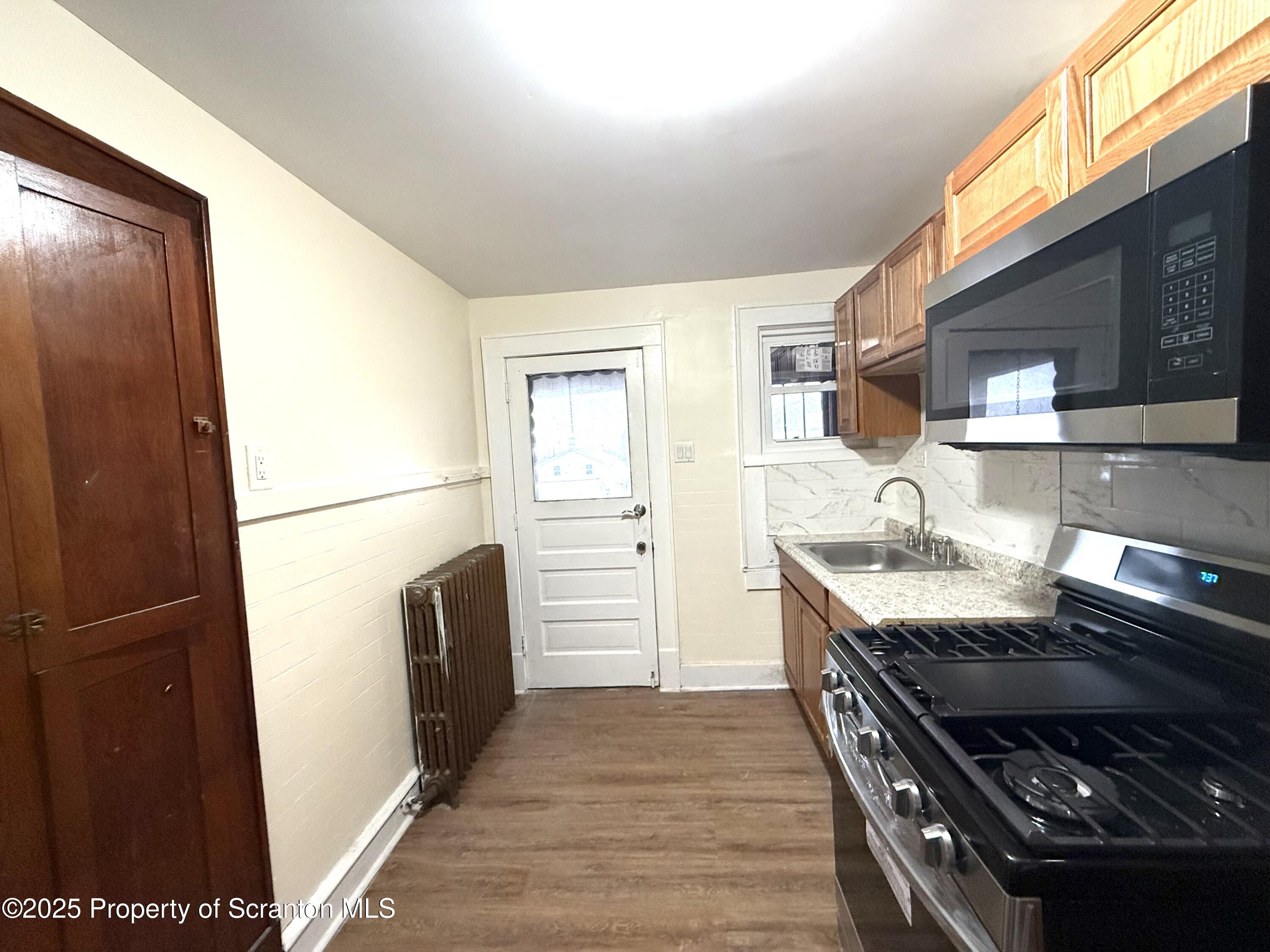 37 Shea Street, Unit 2 Nanticoke, PA 18634 - Photo 8 of 24 a kitchen with granite countertop a refrigerator and a stove