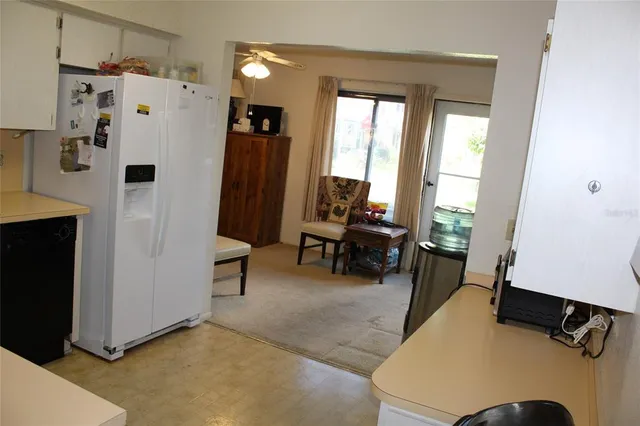 a view of living room with furniture and a refrigerator