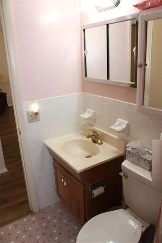 a bathroom with a toilet sink and mirror