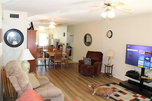 a living room with furniture a clock on wall and a large window