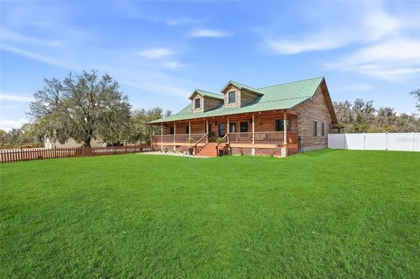 a view of house with wooden floor and wooden fence