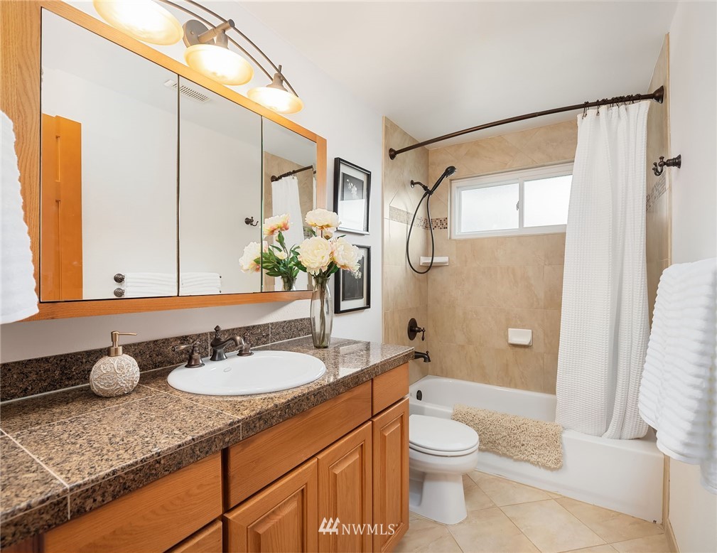 6611 Southeast 5th Place Renton, WA 98059 - Photo 11 of 25 a bathroom with a granite countertop sink toilet and shower