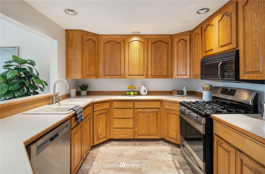 6611 Southeast 5th Place Renton, WA 98059 - Photo 5 of 25 a kitchen with stainless steel appliances granite countertop a sink stove and cabinets