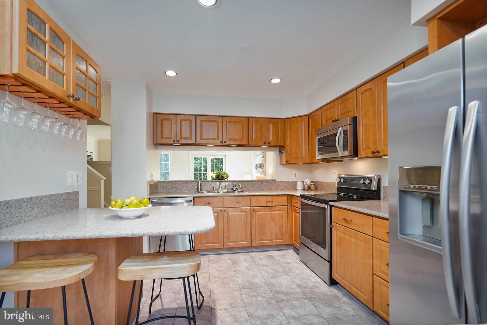 9303 Kendal Circle Laurel, MD 20723 - Photo 2 of 50 a kitchen with stainless steel appliances granite countertop a stove top oven a sink dishwasher a dining table and chairs with wooden floor