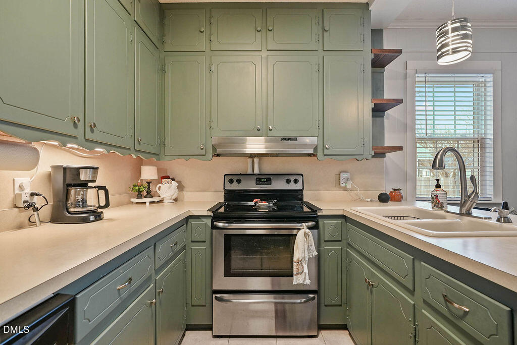 305 South 17th Street Erwin, NC 28339 - Photo 16 of 35 a kitchen with granite countertop a sink stainless steel appliances and cabinets